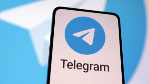 A phone showing the Telegram logo