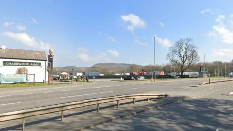 A road with a pub in the background and blue skies above