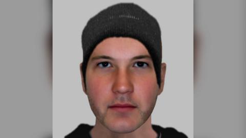 A police e-fit of a man with stubble and a black beanie on