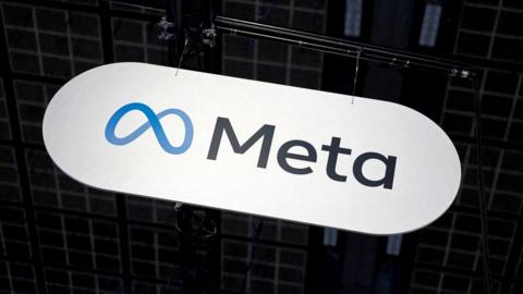 Meta's infinity loop logo in blue next to the company's name in black is seen at a technology conference