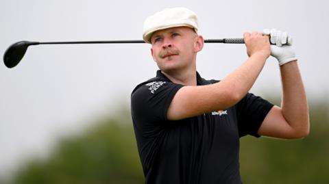 Harry Hall watches on after teeing off