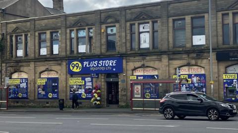 A two-storey building with large yellow and blue signage advertising homeware.