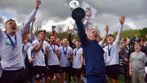 Merthyr Town boss Paul Michael lifts the Southern Premier League South trophy alongside his players 