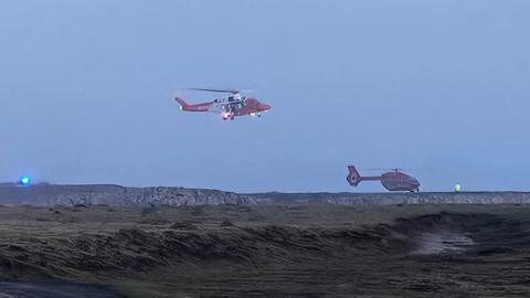 Llun o ddau hofrennydd sy'n chwilio am y tri dringwr yn Gofan, Sir Benfro