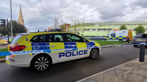 Multiple police cars and a police cordon