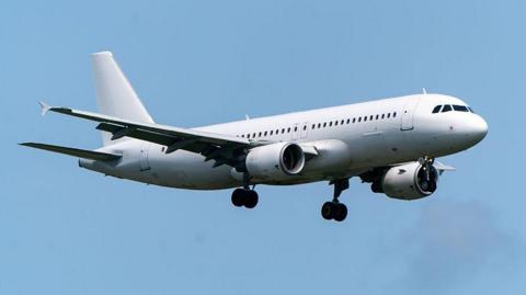 Airbus A320-214 of FlyOne against a blue sky