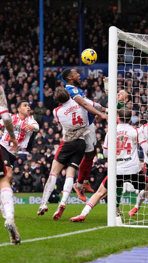 Southampton and Portsmouth players fight for the ball near the goal.