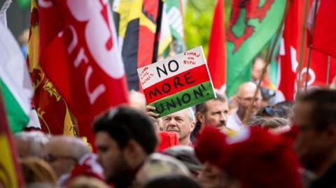 Mae'r llun yn dangos golygfa o orymdaith o blaid annibyniaeth i Gymru