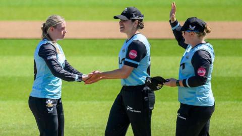 Surrey's Ryana MacDonald-Gay (left) celebrates a wicket with teammates