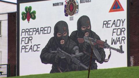 A loyalist paramilitary mural on a gable wall in the Mount Vernon area of north Belfast, showing two masked gunmen alongside text which reads, "Prepared for peace, ready for war".