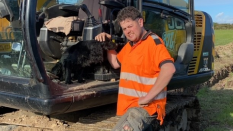 Macauley Owen standing next to a farm vehicle