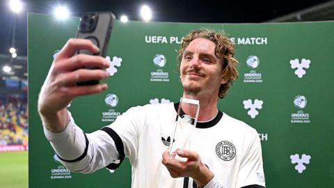 Nick Woltemade takes a selfie with his player of the match award