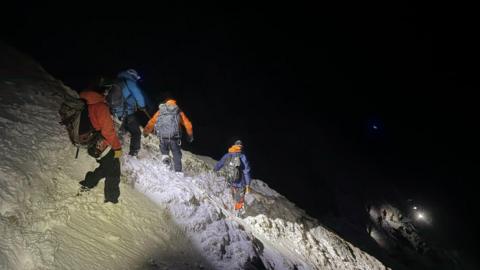 Beanntan air an còmhdachadh le sneachd is Sgioba Teasairginn Bheanntan Ghleann Comhann air a dhol an sàs