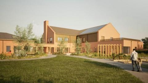 An architects impression of a hospice. It features a two storey building with pitched roof, and a single storey building with a hipped roof. The two buildings are linked by a single storey flat-roof structure, and a single-storey flat roof building extends from the gable of the main building. There are trees and other architectural features, and an adult and child depicted on a footpath.