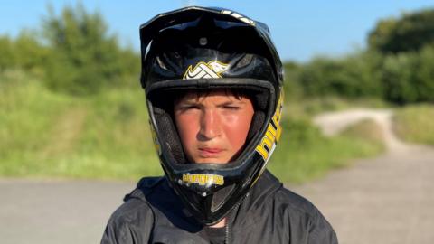 Boy with black biker helmet and black zipper jacket