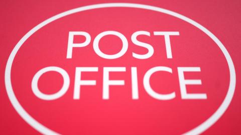 A big red Post Office sign, with a white circle round it
