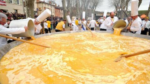 Members of the Giant Omelette Brotherhood of Bessieres cook a giant omelette as part of Easter celebrations.