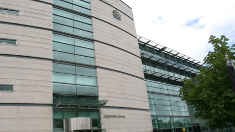 A view of the front of the Laganside Court complex in Belfast with a tree in the foreground