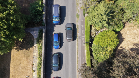 A birds eye view of cars on a narrow street