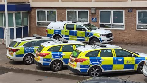Four police vehicles in front of a police station