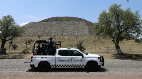 Members of the National Guard stand on a vehicle with the Pyramid of the Moon in the background, at the perimeter of the Teotihuacan pyramids after a gunman killed a Canadian woman and wounded several others before killing himself, authorities said, at one of the country's most visited tourist sites 
