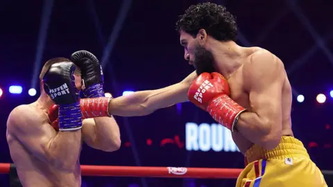 Hamzah Sheeraz throws a punch at Simon Zachenhuber