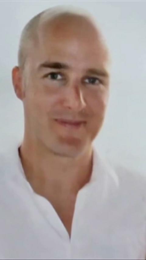 Bald man wearing white shirt looking to camera