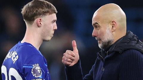 Chelsea player Cole Palmer speaking with Manchester City manager Pep Guardiola