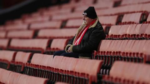 A Sheffield United fan sits alone in Bramall Lane stadium