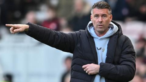 Rob Edwards points on the touchline with outstetched arm