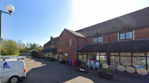 Rainbows Hospice which consists of a red brick building, with blue sky in the background