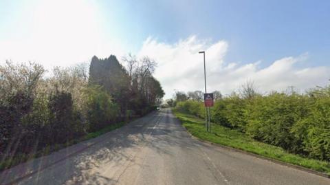 Streetview image of Whitehill Road, Ellistown as it turns into Ellistown Terrace, with hedges on the edge of an industrial estate.