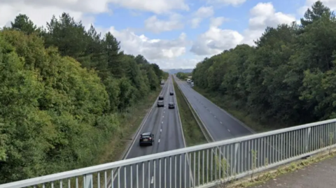 A Google maps screenshot of a section of the A40 road, taken from a bridge above. It is a long and straight dual carriageway with mature trees lining either side.