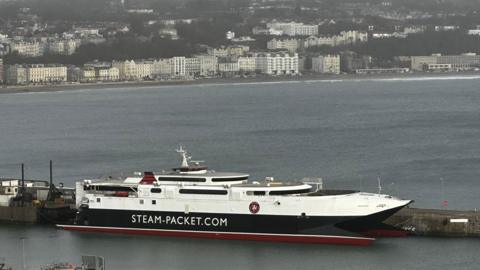 The Manannan, a sleek catamaran, it is moored on Douglas harbour, you can see Douglas prom in the background, on a dull day.