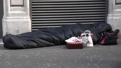 Person sleeping on pavement