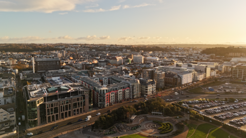 A picture taken from above looking down at Jersey. There is a number of large buildings running into the distance. There is also a number of cars to the right of the image.