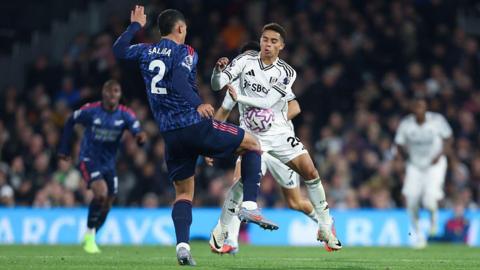William Saliba and Josh King compete for the ball