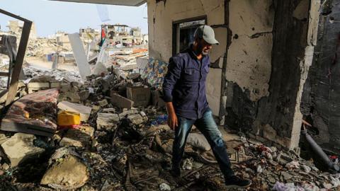 A Palestinian man inspect a damaged house after an Israeli air strike in Khan Younis, southern Gaza (24 April 2025)