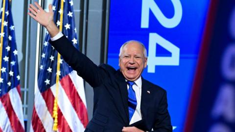 Tim Walz waves to the crowd as he arrives to speak during the Democratic National Convention 