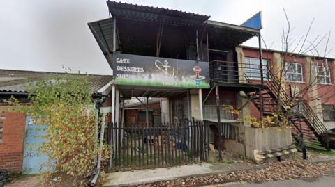 A Google street view image of a two storey former shisha lounge, coloured black, behind