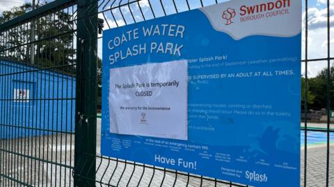A sign on the park gates which says "The Splash Park is temporarily CLOSED. We are sorry for the inconvenience". 