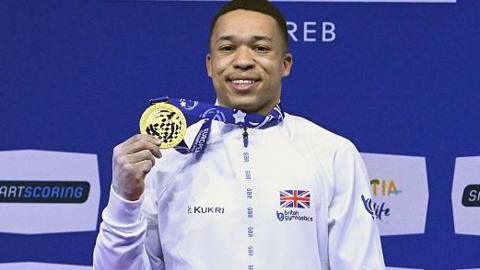 Joe Fraser holds up a gold medal