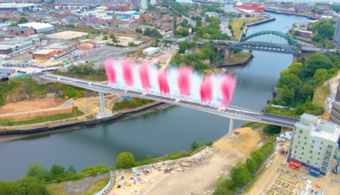 Keel Crossing footbridge when it opened for one day in August for the Women's Rugby World Cup, taken overhead by a drone. Red and white flares - to represents the local football club - can be seen shooting high into the sky.