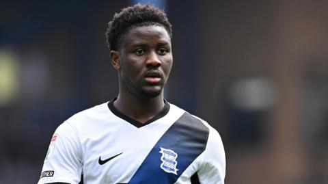 Ibrahim Osman in action for Birmingham City. He is wearing a white away shirt with a dark blue sash.