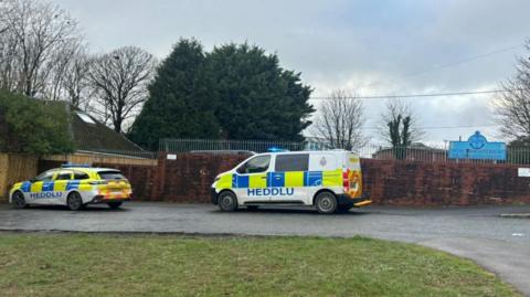 A police car and an ambulance parked in the driveway of Milford Haven School