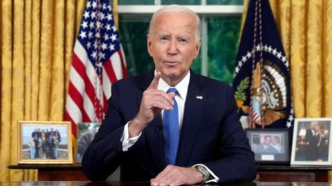 President Joe Biden sitting at desk in Oval Office