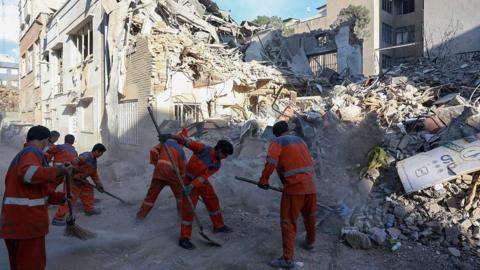 Iranian workers cleans at the site of Israeli-American strikes that according to local media reports destroyed the Rafi-Nia Synagogue and nearby residential buildings in Tehran, on April 7 2026.