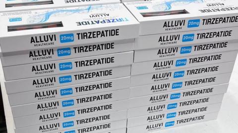 Two tall piles of boxes labeled "TIRZEPATIDE" are stacked on a table