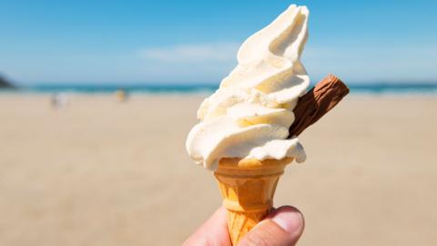 Mr Whippy ice cream with a flake in a cone on a beach