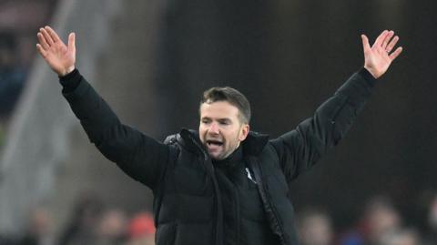 Watford manager Tom Cleverley throws his arms in the air to celebrate as the final whistle goes at Middlesbrough v Watford